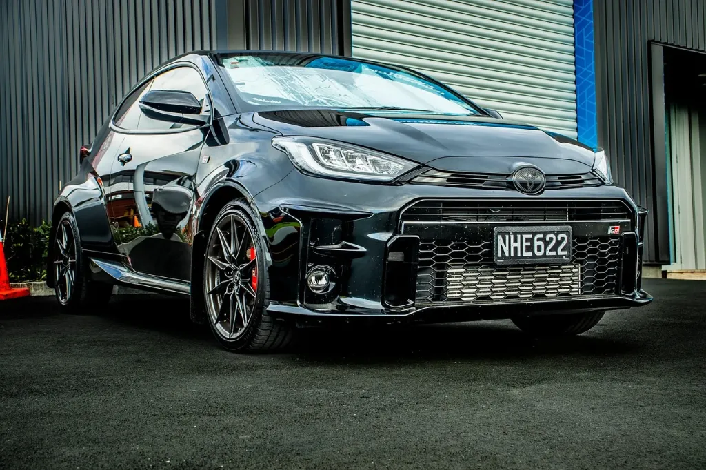 Komora silnika nowoczesnego SUV-a z narzędziami warsztatowymi w tle, symbolizująca profesjonalny serwis Toyoty Highlander.